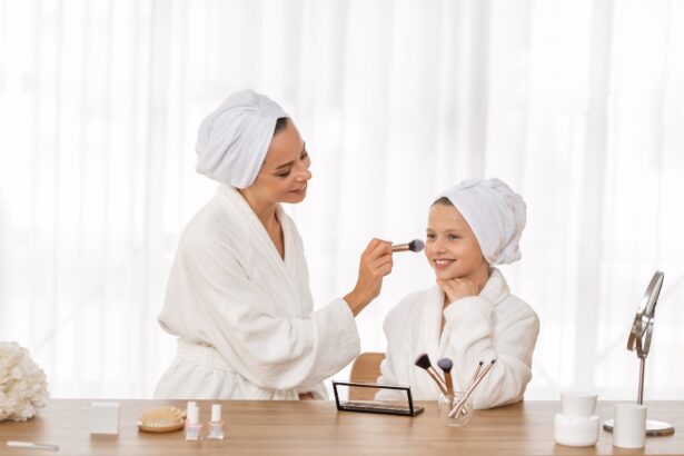 Loving mother and her little daughter in bathrobes doing makeup at home