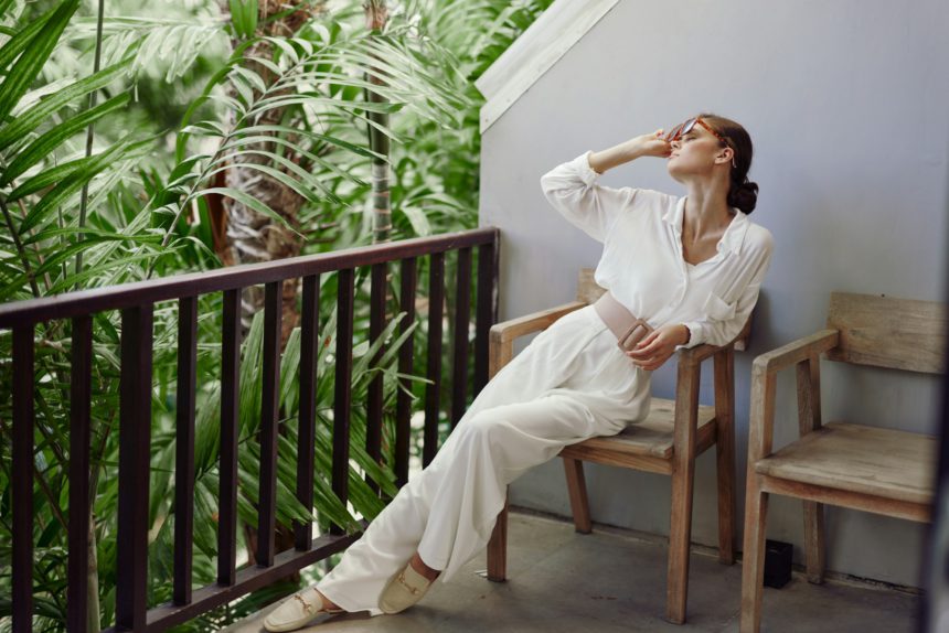 Tropical Getaway Smiling Woman on Balcony Enjoying Vacation Relaxation This trendy portrait captures