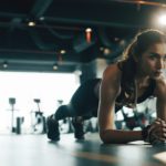 Young woman doing plank exercise while exercising in gym.