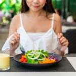 Young woman eating healthy salad at restaurant, Healthy lifestyle and diet concept